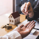 Estate agent giving house keys to client after signing agreement contract real estate with approved mortgage application form, concerning mortgage loan offer for and house insurance.